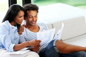 Couple sitting on a couch looking at papers